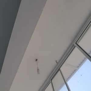 תקרה צבועה בלבן עם נורה תלויה