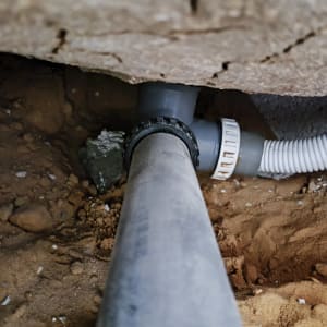 צינור פלסטיק מחובר למערכת ביוב מתחת לאדמה