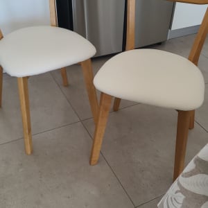 כיסאות עץ עם ריפוד לבן על המושבים