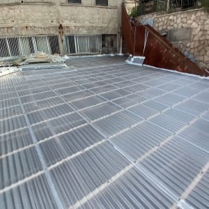 גג מתכת עם לוחות שקופים ומסגרת ברזל