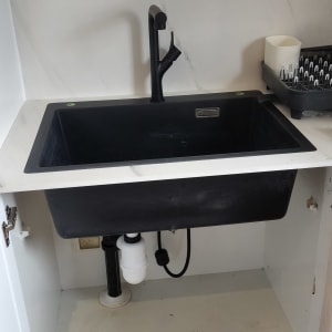 כיור שחור עם ברז, צנרת מתחת לכיור