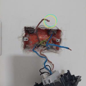 חוטי חשמל חשופים בקיר עם מתג מנותק