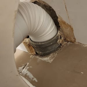 צינור פלסטיק לבן מחובר לקיר עם חור