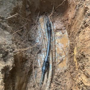 תמונה של צינור מים באדמה רטובה