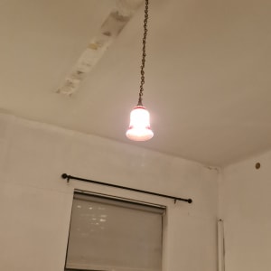 מנורה תלויה מהתקרה בחדר עם חלון