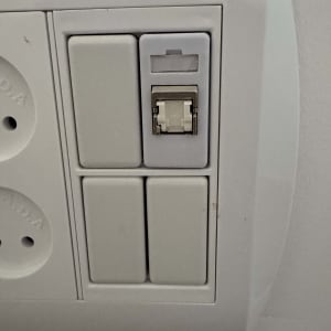 שקע רשת תקשורת RJ45 מותקן בקיר לצד שקעי חשמל