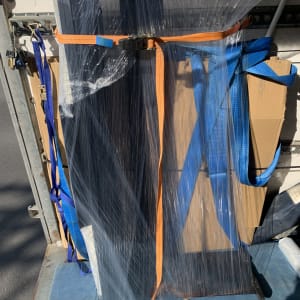 רהיט עטוף בניילון עם רצועות כתומות וכחולות