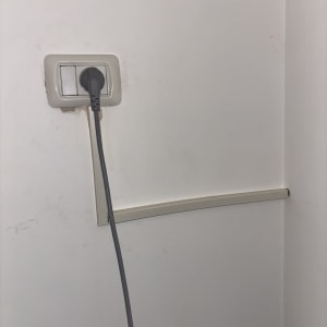 שקע חשמלי עם כבל מחובר לקיר לבן