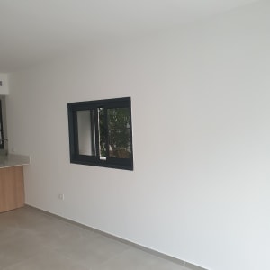 קיר צבוע בלבן עם חלון שחור