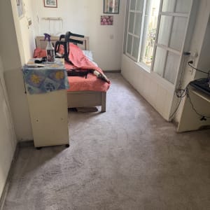 בקבוק תרסיס על שולחן, שואב אבק על מיטה