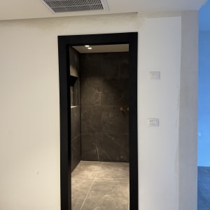 פתח דלת עם מסגרת שחורה וקירות אפורים