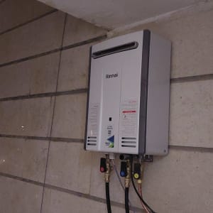 מחמם מים גז מותקן על קיר עם צינורות מחוברים