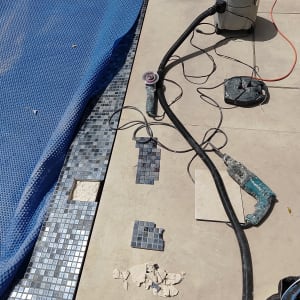 כלי עבודה לתיקון אריחים ליד בריכה