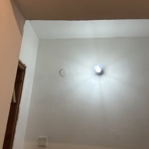 קיר צבוע עם מנורה דולקת בתקרה