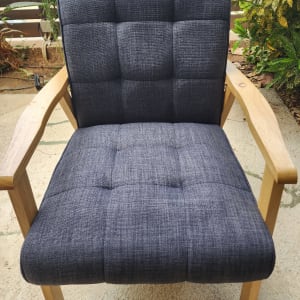 כיסא מרופד אפור עם מסגרת עץ בגינה