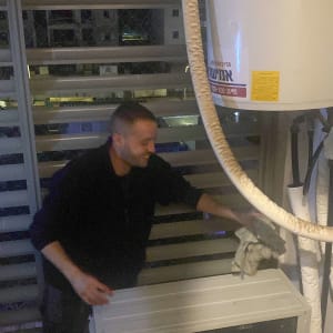 אדם ליד דוד שמש עם צינורות מבודדים