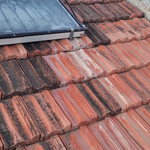 רעפים אדומים עם לוח סולארי על הגג