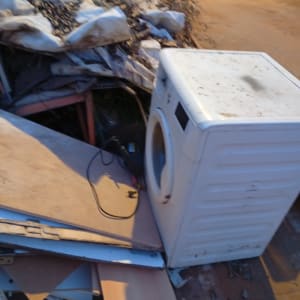 מכונת כביסה ישנה ופסולת בניין ברחוב