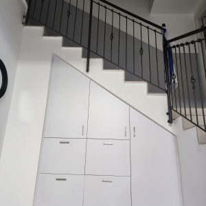 ארון לבן מתחת למדרגות עם ידיות מתכת