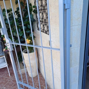 שער מתכת צבוע בצבע אפור ליד קיר אבן