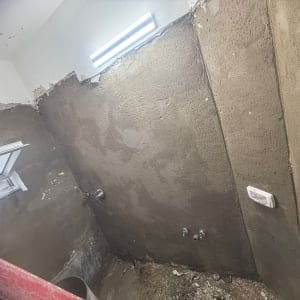 קיר בטון עם חלון פתוח ועבודות שיפוץ