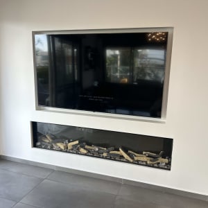 טלוויזיה תלויה על קיר מעל אח דקורטיבי