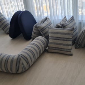 כריות וספות מונחות על רצפה ליד חלון.