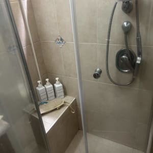 מקלחת עם ראש מקלחת, בקבוקי סבון וספוג רחצה