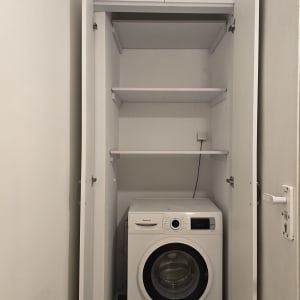 מכונת כביסה בארון עם מדפים פתוחים