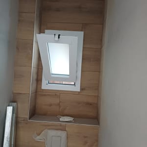חלון אלומיניום מותקן בקיר עם חיפוי עץ