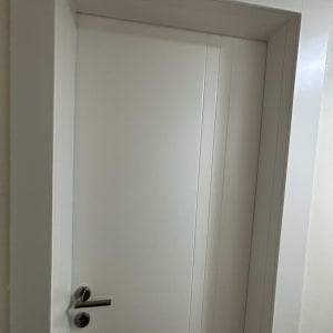 דלת לבנה עם ידית מתכת כסופה