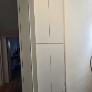 בוידעם מעץ בלכה לבנה מותקן מתחת לתקרה מעל מעבר
