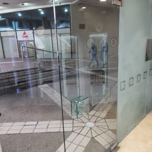 דלת זכוכית עם ידית מתכת ומנגנון סגירה