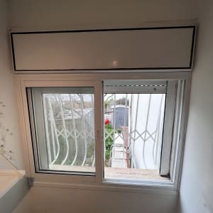 תריסים לבנים סגורים בחלק העליון של חלון