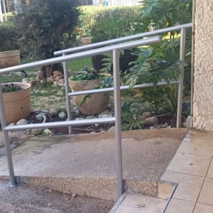 מעקה מתכת על רמפה ליד גינה