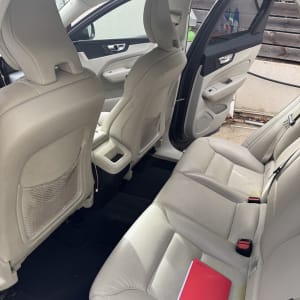 מושב אחורי של רכב עם מושבים נקיים ופנקס אדום