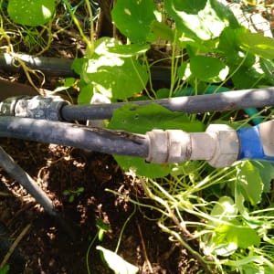 צינורות מחוברים עם מחבר מתכת בגינה