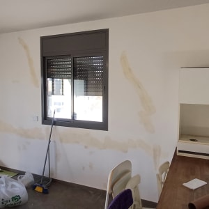 חדר עם קירות צבועים חלקית וכלי עבודה