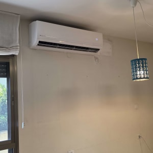 מזגן מותקן על קיר בחדר עם מנורה