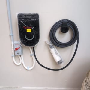 מטען לרכב חשמלי עם כבל טעינה על קיר