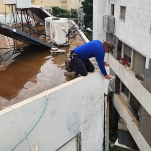 אדם עובד על גג עם מים ומזגנים