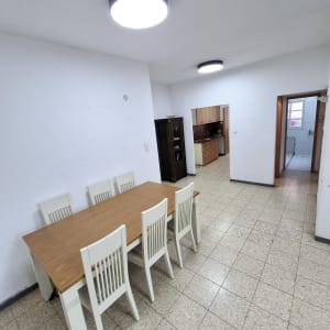 שולחן עץ עם שישה כיסאות בחדר אוכל מואר