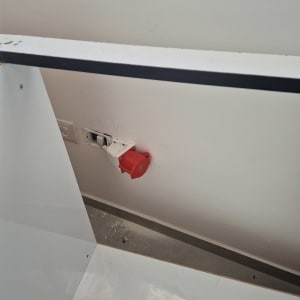 שקע חשמלי עם כיסוי אדום על קיר לבן