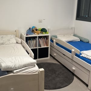 חדר ילדים עם שתי מיטות צעצועים וספרים