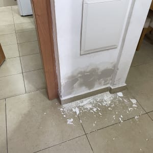 קיר עם טיח מתקלף ורצפה עם שברי טיח