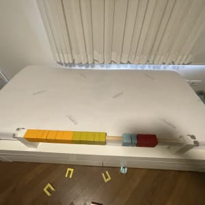 מזרן לבן עם קוביות צבעוניות על מיטה