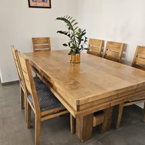 כיסאות עץ עם ריפוד גיאומטרי ליד שולחן עץ