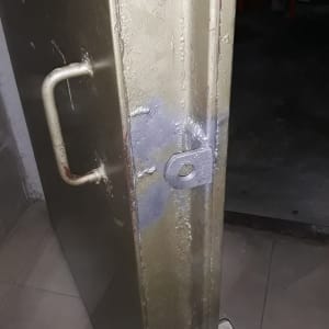 דלת מתכת עם ידית ומנעול ברזל