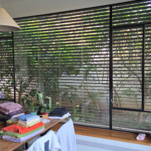 מגבות מקופלות על שולחן ליד חלון עם תריסים