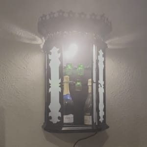 מנורה מעוצבת עם בקבוקי יין על קיר